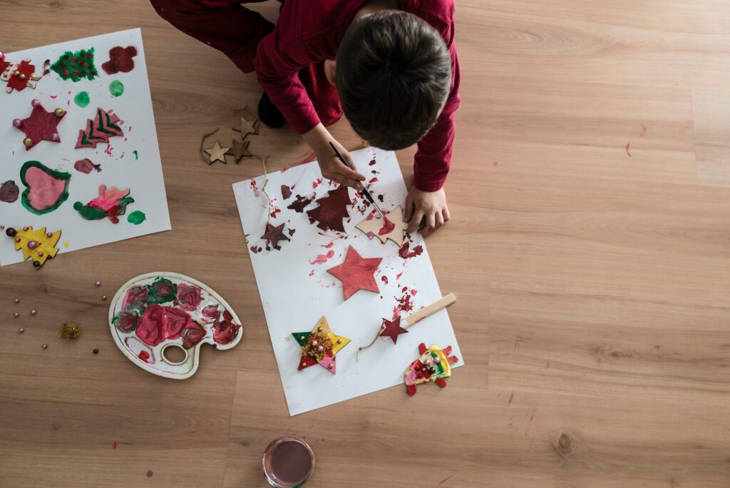 Boy painting wooden Christmas handicrafts