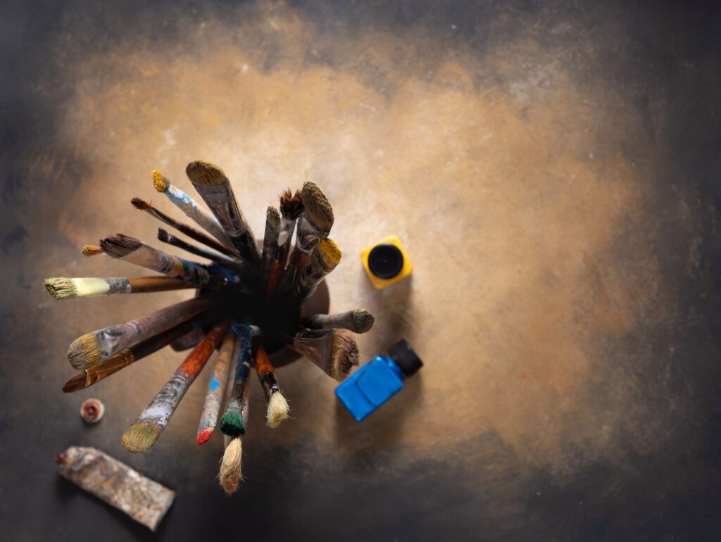 Paint brush in clay jug and art painter tool on abstract background texture. Paintbrush painting